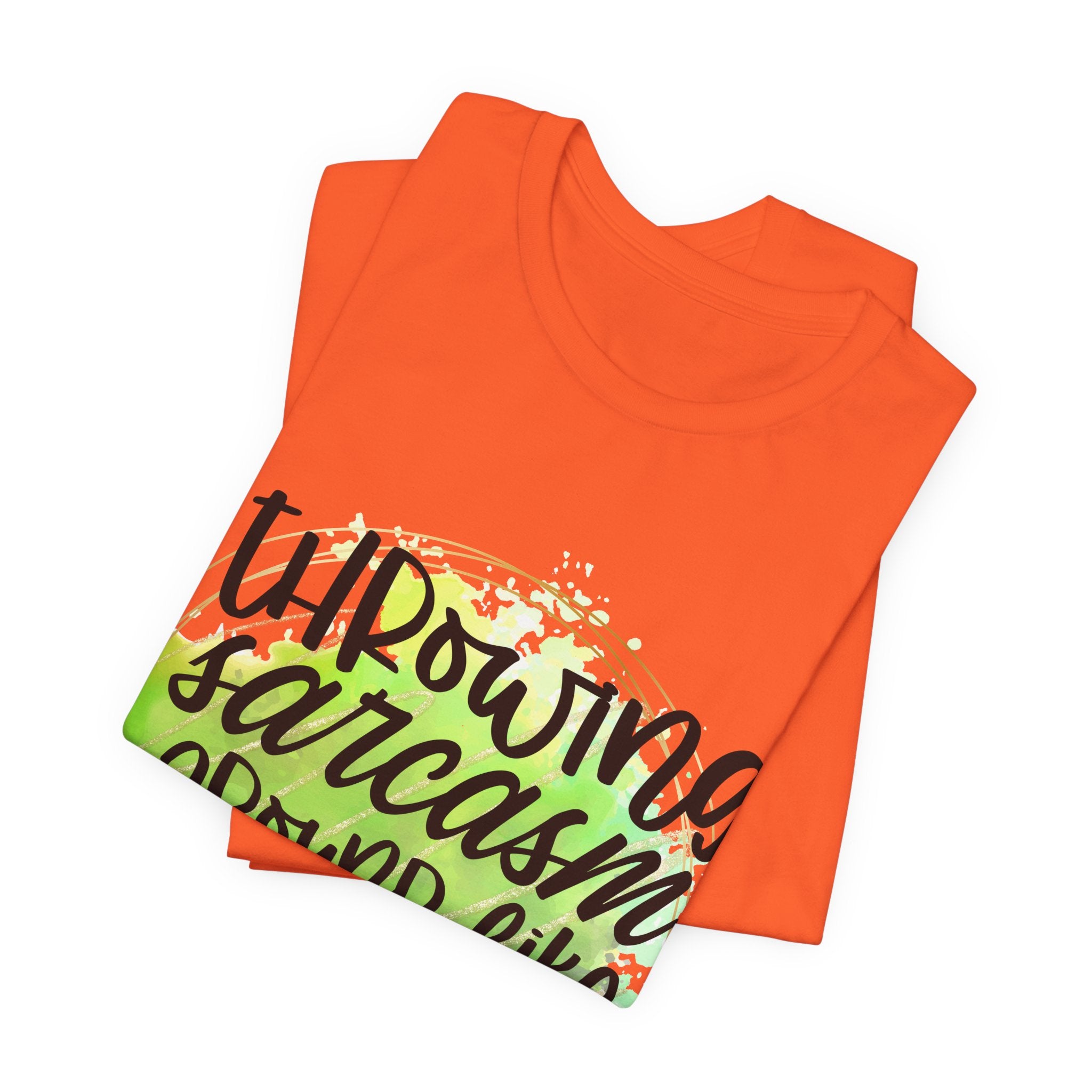 Orange t-shirt folded with colorful text design on a white background